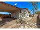 Exterior view showcasing a covered patio, desert landscaping, and a bright blue sky backdrop at 115 S Stardust Ln, Apache Junction, AZ 85120