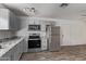 Well-lit kitchen featuring stainless steel appliances, granite countertops, and gray cabinetry at 115 S Stardust Ln, Apache Junction, AZ 85120