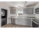 Updated kitchen featuring gray cabinets, stainless steel appliances, granite countertops, and a modern washer/dryer at 115 S Stardust Ln, Apache Junction, AZ 85120
