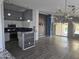 Open-concept living room with wood flooring, white cabinets, backyard access, and modern light fixture at 11760 N 153Rd Ave, Surprise, AZ 85379