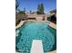 Backyard pool featuring a diving board, rock waterfall, brick surround, and desert landscaping at 11760 N 153Rd Ave, Surprise, AZ 85379