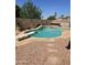 Backyard pool with diving board and rock waterfall surrounded by desert landscaping at 11760 N 153Rd Ave, Surprise, AZ 85379