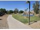 Community walking path with green spaces, palm trees, and blue basketball court at 11760 N 153Rd Ave, Surprise, AZ 85379