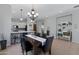 Cozy dining room with a six-chair table, decorative chandelier, and adjacent kitchen area at 12946 N Northstar Dr, Fountain Hills, AZ 85268