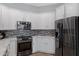 Modern kitchen with stainless steel appliances, grey backsplash, white cabinets and granite countertops at 12946 N Northstar Dr, Fountain Hills, AZ 85268