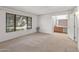 Spacious bedroom featuring a large window, neutral carpet, and an en-suite bathroom at 14123 W Yosemite Dr, Sun City West, AZ 85375