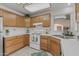 Well-lit kitchen with wood cabinets, white appliances, and ample counter space at 14123 W Yosemite Dr, Sun City West, AZ 85375