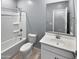 Bright bathroom features shower-tub combination with white vanity and tiled flooring at 14154 W Voltaire St, Surprise, AZ 85379