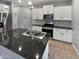 Modern kitchen features stainless steel appliances, white cabinetry, and granite countertops at 14154 W Voltaire St, Surprise, AZ 85379
