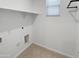 Clean and bright laundry room features tile flooring, utility hookups and a small window at 14154 W Voltaire St, Surprise, AZ 85379