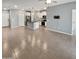 Open-concept living room with tile floors leading into a modern kitchen with white cabinets at 14154 W Voltaire St, Surprise, AZ 85379
