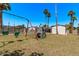 Backyard offering a swing set and climbing structure under the bright sky and surrounded by tall palm trees at 1431 E San Juan Ave, Phoenix, AZ 85014