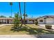 Charming single-story home featuring a well-manicured lawn, mature palm trees and a cozy, inviting facade at 1431 E San Juan Ave, Phoenix, AZ 85014