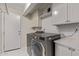 Well-lit laundry room features front loading washer/dryer, storage cabinets and access to the exterior at 1431 E San Juan Ave, Phoenix, AZ 85014