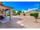 Expansive backyard featuring desert landscaping, stone pavers, a covered patio, and block wall fencing at 14770 W Voltaire St, Surprise, AZ 85379