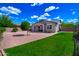 Well-maintained backyard with desert landscaping, small grass area, and a charming covered patio at 14770 W Voltaire St, Surprise, AZ 85379