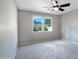 Bright bedroom showcases carpet, a ceiling fan, and two windows, creating a cozy and airy atmosphere at 14770 W Voltaire St, Surprise, AZ 85379