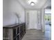 Bright foyer featuring wood-look tile flooring, modern lighting, and a decorative console table at 14770 W Voltaire St, Surprise, AZ 85379
