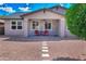 Charming single-story home featuring a quaint front porch with seating and low-maintenance desert landscaping at 14770 W Voltaire St, Surprise, AZ 85379