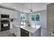 Bright kitchen features an island, stainless steel appliances, and a farmhouse sink at 14770 W Voltaire St, Surprise, AZ 85379