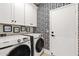 Practical laundry room with black and white patterned accent wall, modern appliances, and ample storage at 15240 N Clubgate Dr # 137, Scottsdale, AZ 85254