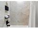 Close-up of modern shower with sleek black hardware, neutral colored textured tile, and built-in storage at 15240 N Clubgate Dr # 137, Scottsdale, AZ 85254