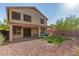 Back exterior featuring covered patio, synthetic lawn, and gravel area at 15432 W Yucatan Dr, Surprise, AZ 85379