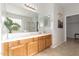 Bright bathroom features wood cabinets, a large mirror, and a glass-enclosed shower at 15432 W Yucatan Dr, Surprise, AZ 85379