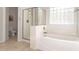 Bathroom featuring a shower and tub combination with tiled walls and a glass block window at 15432 W Yucatan Dr, Surprise, AZ 85379