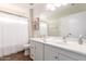 Well-lit bathroom featuring a double sink vanity, white cabinets, and neutral-toned walls at 15432 W Yucatan Dr, Surprise, AZ 85379