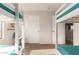 This bedroom features two bunkbeds with green blankets, a door, and a sliding door closet at 15432 W Yucatan Dr, Surprise, AZ 85379