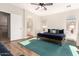 Well-lit bedroom showcases a bed, ceiling fan, and ensuite bathroom at 15432 W Yucatan Dr, Surprise, AZ 85379