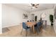 Open dining area with tile floors, wooden table with blue chairs, and modern wall art at 15432 W Yucatan Dr, Surprise, AZ 85379