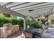 Outdoor grill and dining area under a wooden pergola, surrounded by lush greenery at 16013 S Desert Foothills Pkwy # 2130, Phoenix, AZ 85048