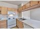 Well-lit kitchen with light wood cabinets, white appliances, and a double basin sink at 16013 S Desert Foothills Pkwy # 2130, Phoenix, AZ 85048