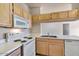 Charming kitchen showcasing light wood cabinetry, white appliances, and ample counter space at 16013 S Desert Foothills Pkwy # 2130, Phoenix, AZ 85048