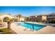 A community pool with lounge chairs and palm trees at 16013 S Desert Foothills Pkwy # 2130, Phoenix, AZ 85048