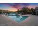 A beautiful view of the community pool at sunset with lounge chairs and a clear, blue swimming pool at 16013 S Desert Foothills Pkwy # 2130, Phoenix, AZ 85048