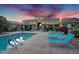 A relaxing view of the community pool with blue lounge chairs and a nearby clubhouse at 16013 S Desert Foothills Pkwy # 2130, Phoenix, AZ 85048