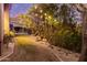 Cozy backyard with bistro lights, desert landscaping, covered patio and view of the mountains in the distance at 16469 N 113Th Way, Scottsdale, AZ 85255