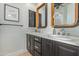 Modern bathroom with double sinks, dark wood cabinets, gold hardware, and white marble countertops at 16469 N 113Th Way, Scottsdale, AZ 85255