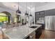 This contemporary open concept kitchen flows into a dining space and features modern lighting at 16469 N 113Th Way, Scottsdale, AZ 85255