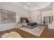 A luxurious main bedroom featuring hardwood floors, a tray ceiling, and a sitting area with an artistic fireplace at 16469 N 113Th Way, Scottsdale, AZ 85255