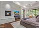 This spacious main bedroom offers a cozy fireplace, wood floors, and large windows with backyard views at 16469 N 113Th Way, Scottsdale, AZ 85255