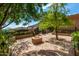 Tranquil outdoor space with a fire pit, mature trees, and manicured landscaping at 16469 N 113Th Way, Scottsdale, AZ 85255