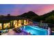 Night view of the backyard pool with lights and mountain views in the distance at 16469 N 113Th Way, Scottsdale, AZ 85255