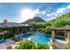 An exquisite backyard pool area features a spa, lush landscaping, and mountain views at 16469 N 113Th Way, Scottsdale, AZ 85255