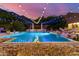 Inviting pool illuminated by string lights, set against a vibrant sunset backdrop at 16469 N 113Th Way, Scottsdale, AZ 85255