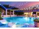 Luxurious pool with string lights, lounge chairs, and manicured landscaping at twilight at 16469 N 113Th Way, Scottsdale, AZ 85255