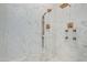 Marble-tiled shower with bronze fixtures including dual shower heads and body jets at 16469 N 113Th Way, Scottsdale, AZ 85255
